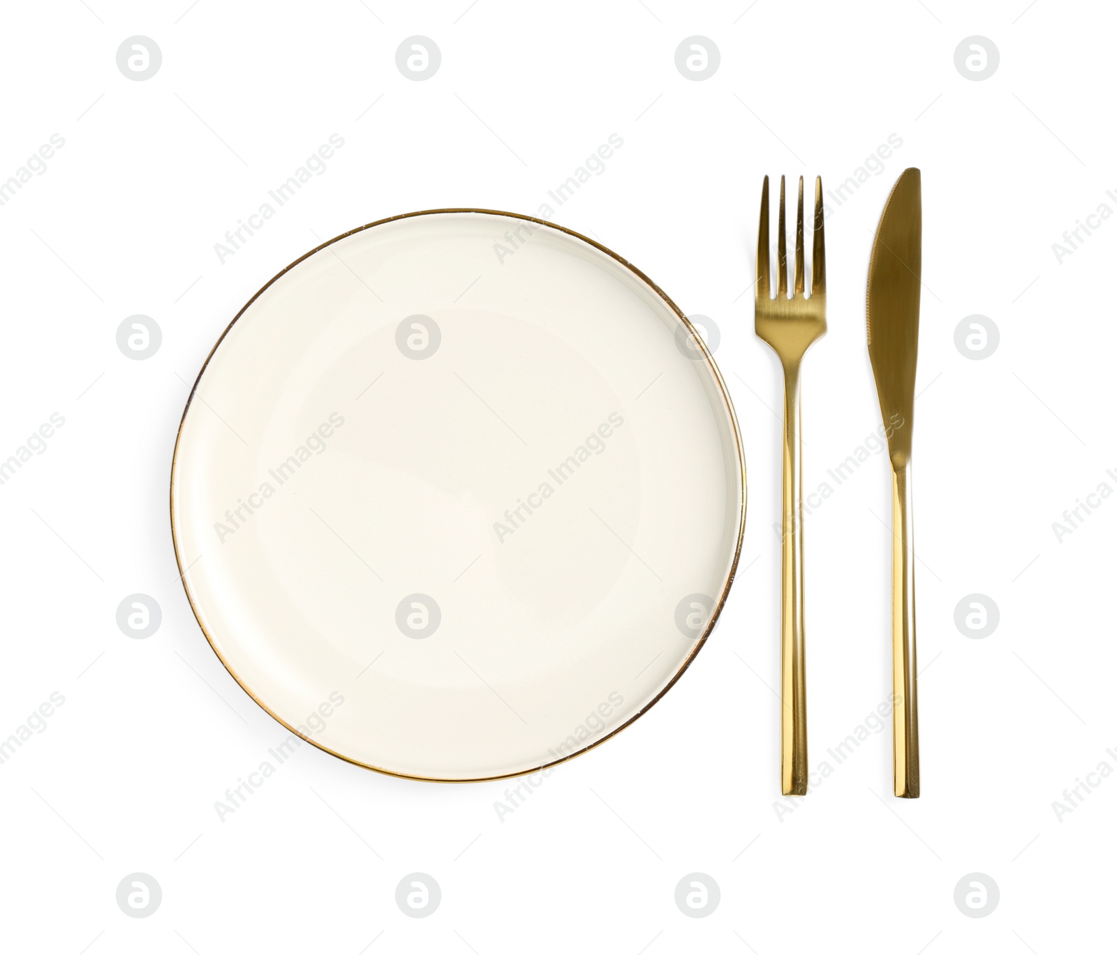 Photo of Clean plate and golden cutlery on white background, top view