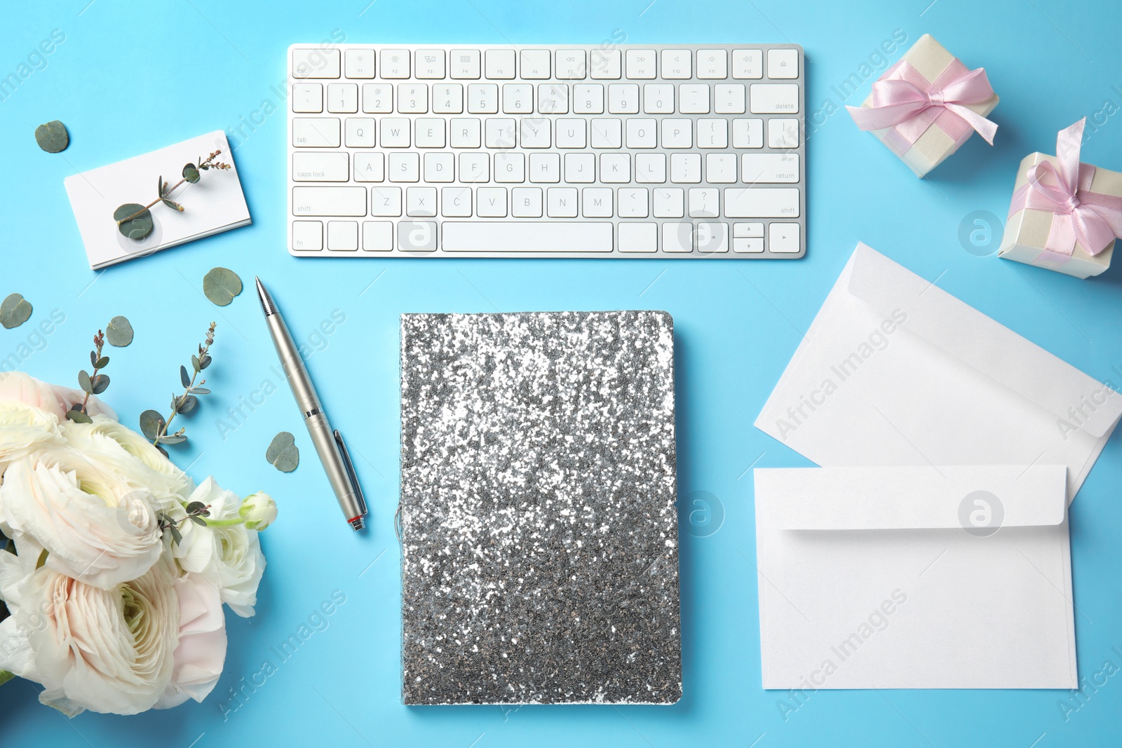 Photo of Flat lay composition with glittering notebook, keyboard and spring flowers on color background