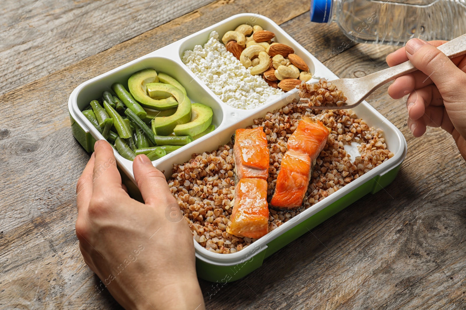 Photo of Woman eating natural protein food from container at table