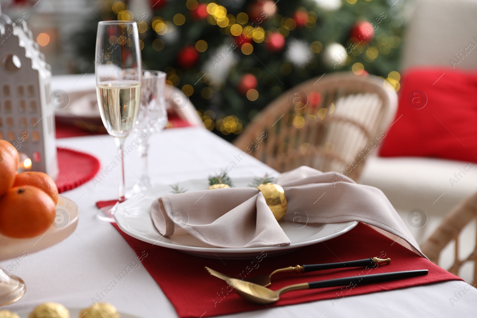 Photo of Christmas table setting with beautiful napkin, cutlery and dishware indoors, closeup