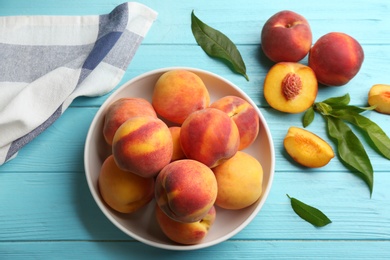 Photo of Fresh sweet peaches on turquoise wooden table, top view