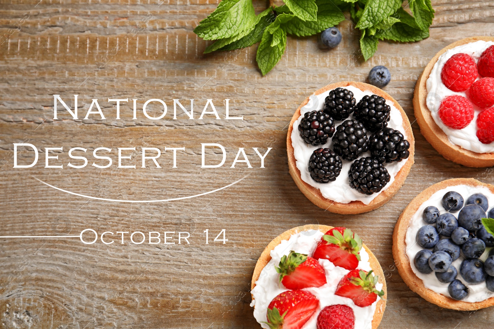 Image of National Dessert Day, October 14. Tasty tartlets with different fresh berries on wooden table, flat lay