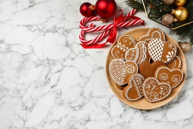 Tasty heart shaped gingerbread cookies and Christmas decor on white marble table, flat lay. Space for text