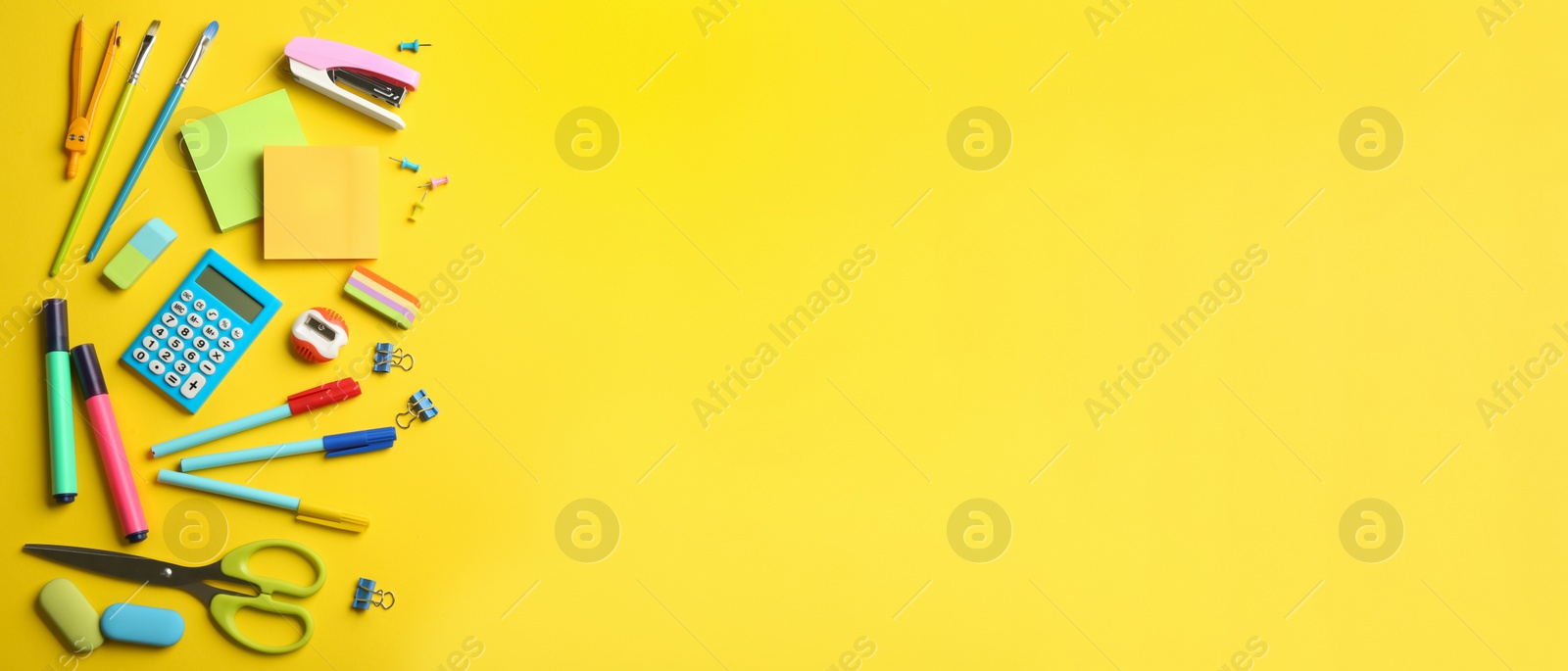 Photo of School stationery on yellow background, flat lay with space for text. Back to school