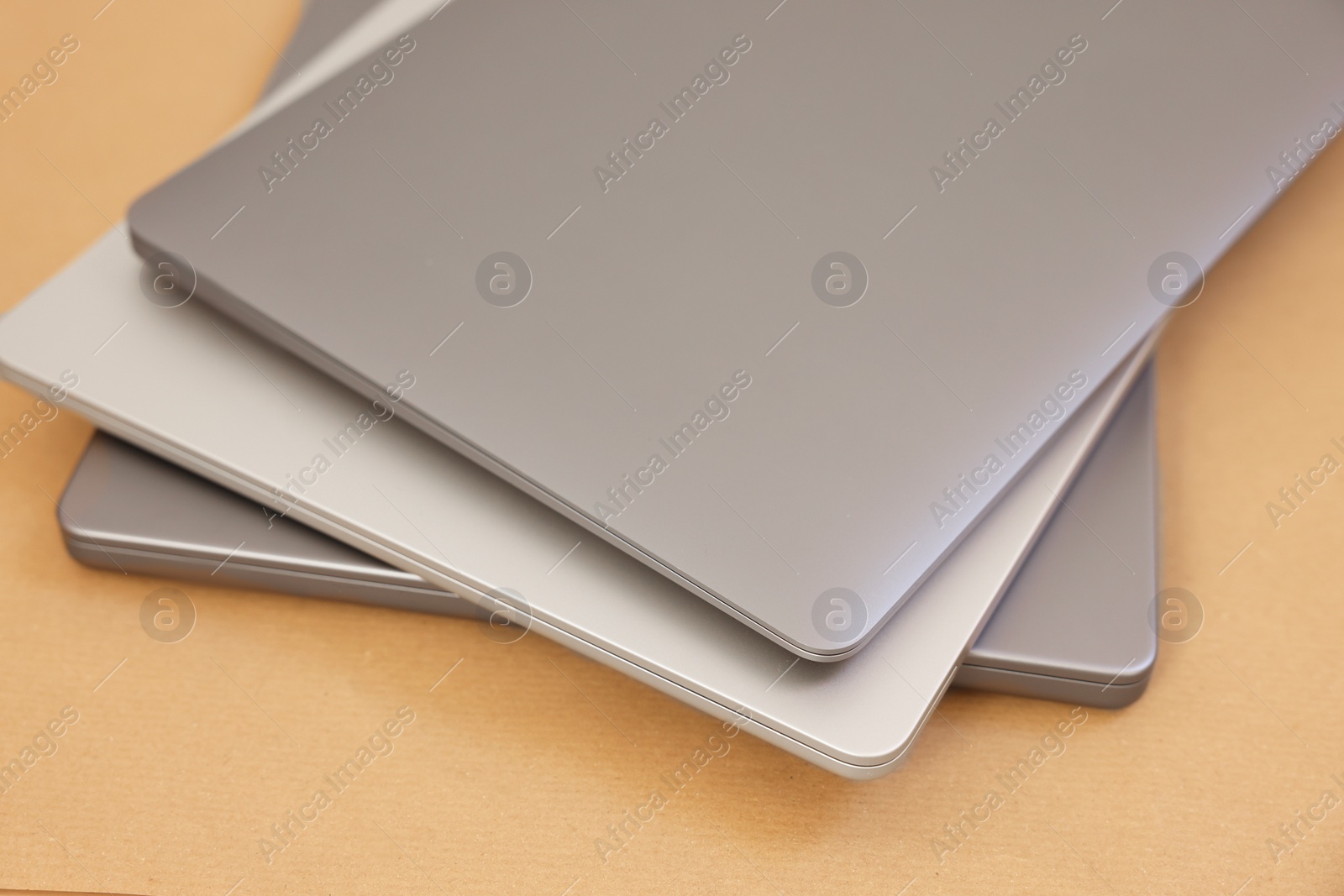 Photo of Different modern laptops on brown background, closeup