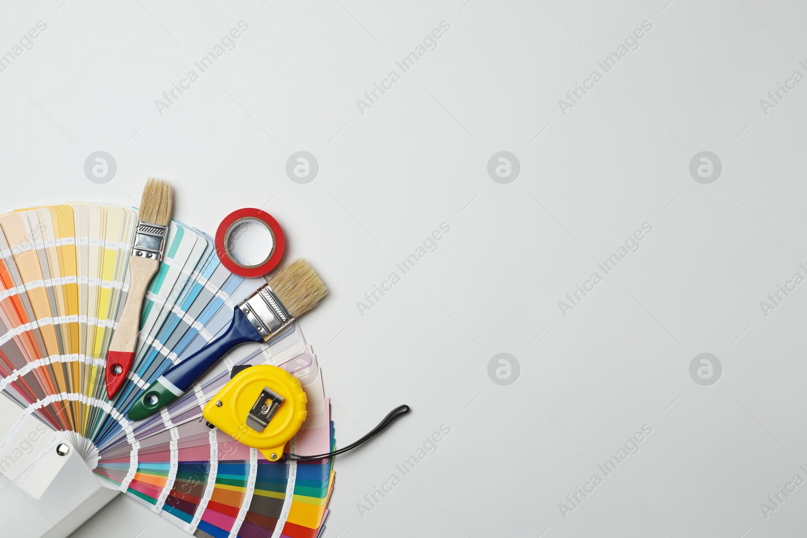 Photo of Set of decorator's tools on light background, flat lay