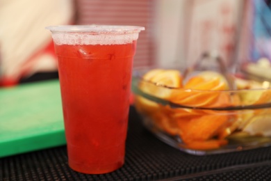 Photo of Delicious refreshing drink in plastic cup on bar counter