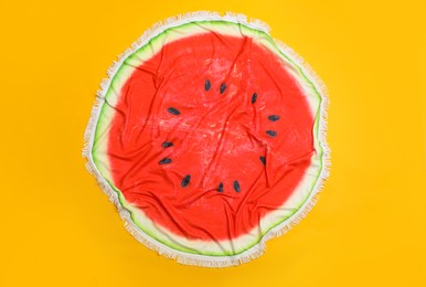 Crumpled round watermelon beach towel on yellow background, top view