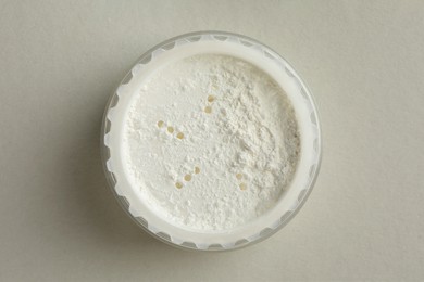 Rice loose face powder on light grey background, top view. Makeup product