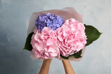 Photo of Woman with bouquet of beautiful hortensia flowers on color background, closeup