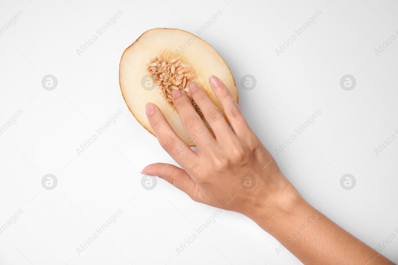 Photo of Young woman touching half of melon on white background, top view. Sex concept