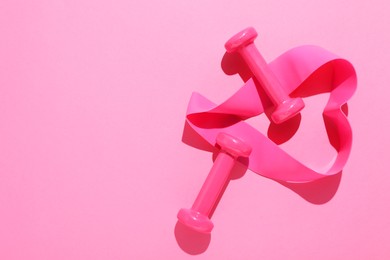 Photo of Dumbbells and fitness elastic band on pink background, flat lay. Space for text