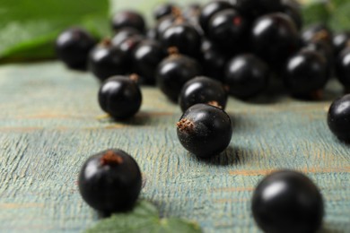 Photo of Ripe blackcurrants and leaves on wooden rustic table, closeup