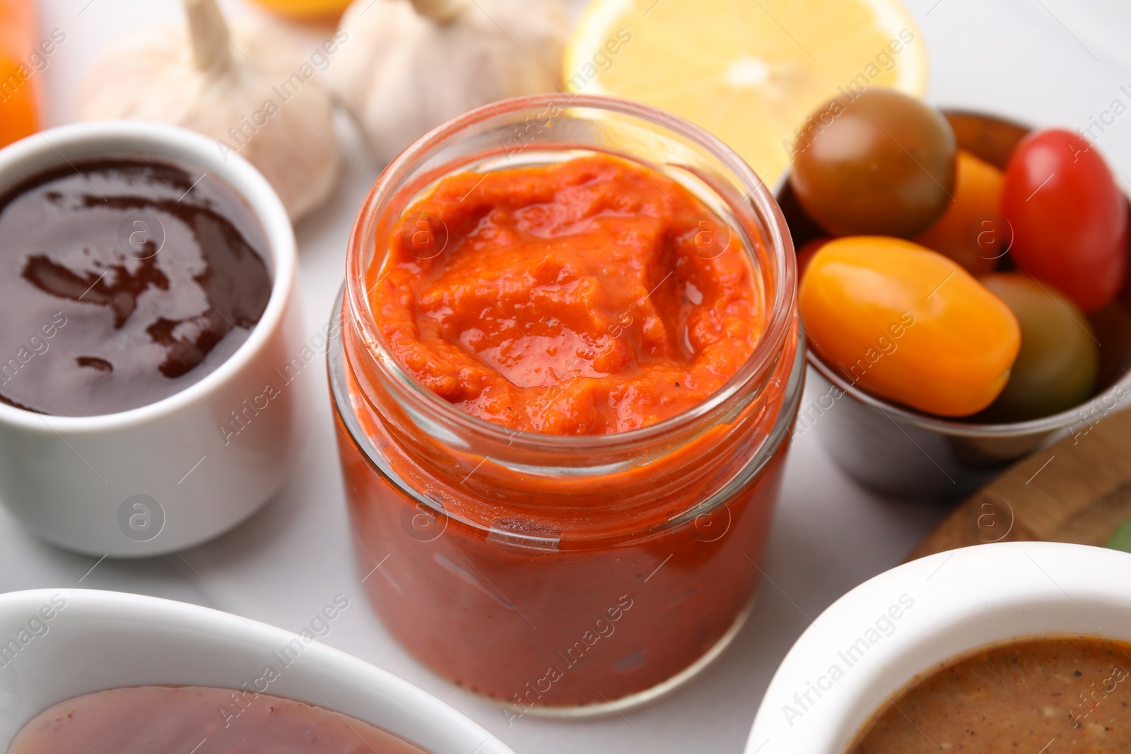 Photo of Different marinades in tableware on white table, closeup