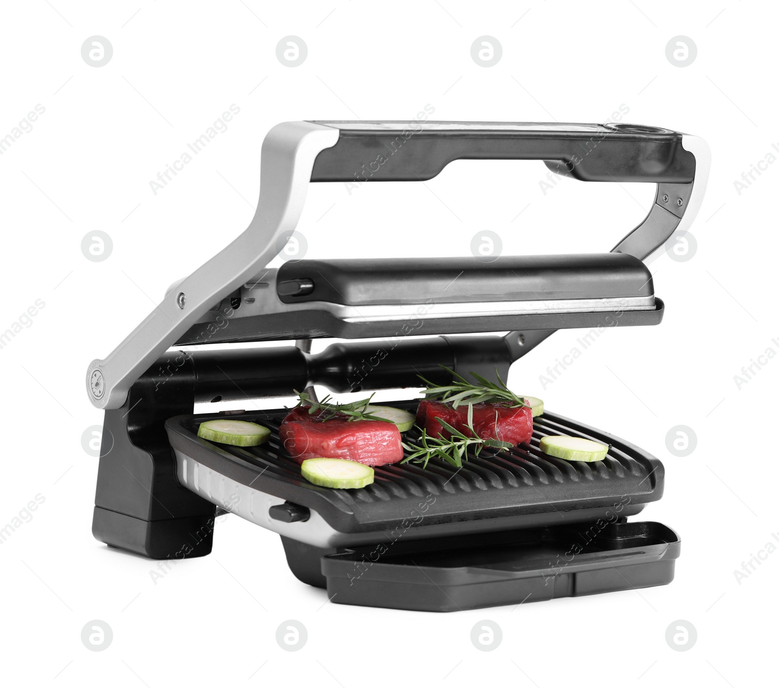 Photo of Electric grill with raw meat, zucchini and rosemary isolated on white