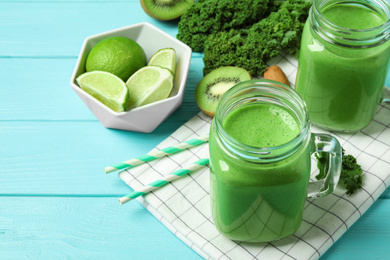 Tasty fresh kale smoothie on light blue wooden table