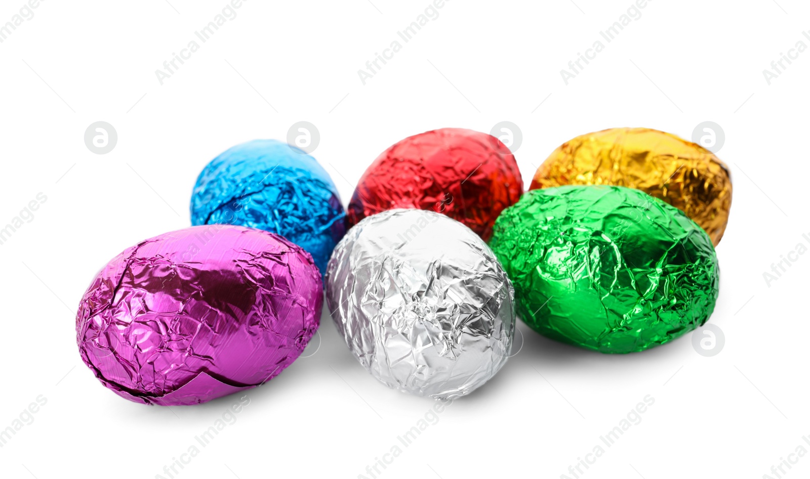 Photo of Many chocolate eggs wrapped in bright foil on white background