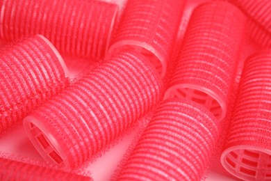 Hair curlers on pink background, closeup. Styling tool