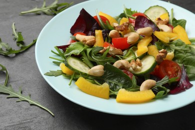 Photo of Tasty fresh vegetarian salad on black table, closeup