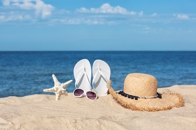 Composition with beach accessories on sand near sea in summer