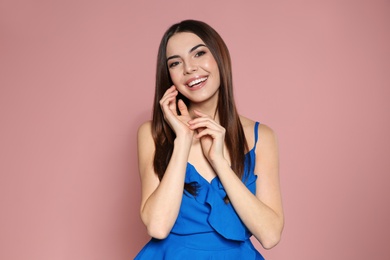 Photo of Portrait of beautiful smiling woman in stylish clothes on pink background