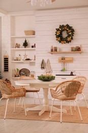 Cozy dining room interior with beautiful Christmas wreath