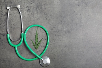 Photo of Stethoscope, hemp leaf and space for text on grey background, top view