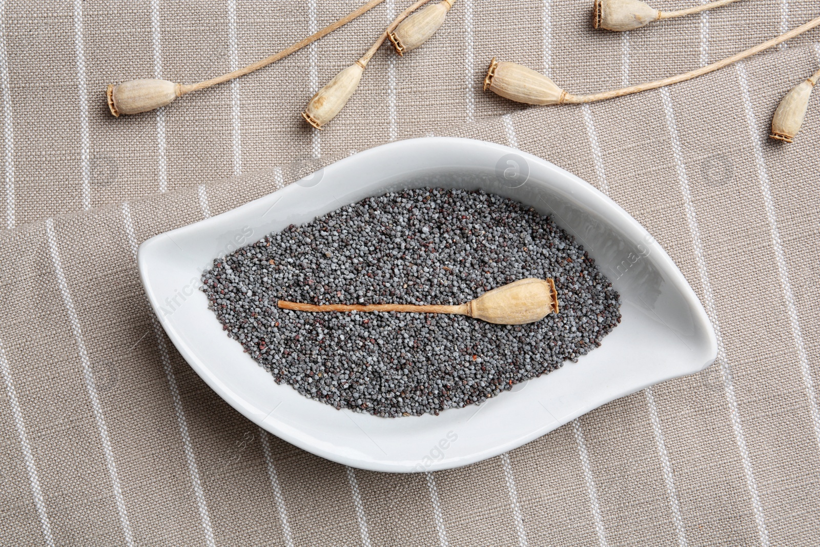 Photo of Flat lay composition with poppy seeds on striped cloth