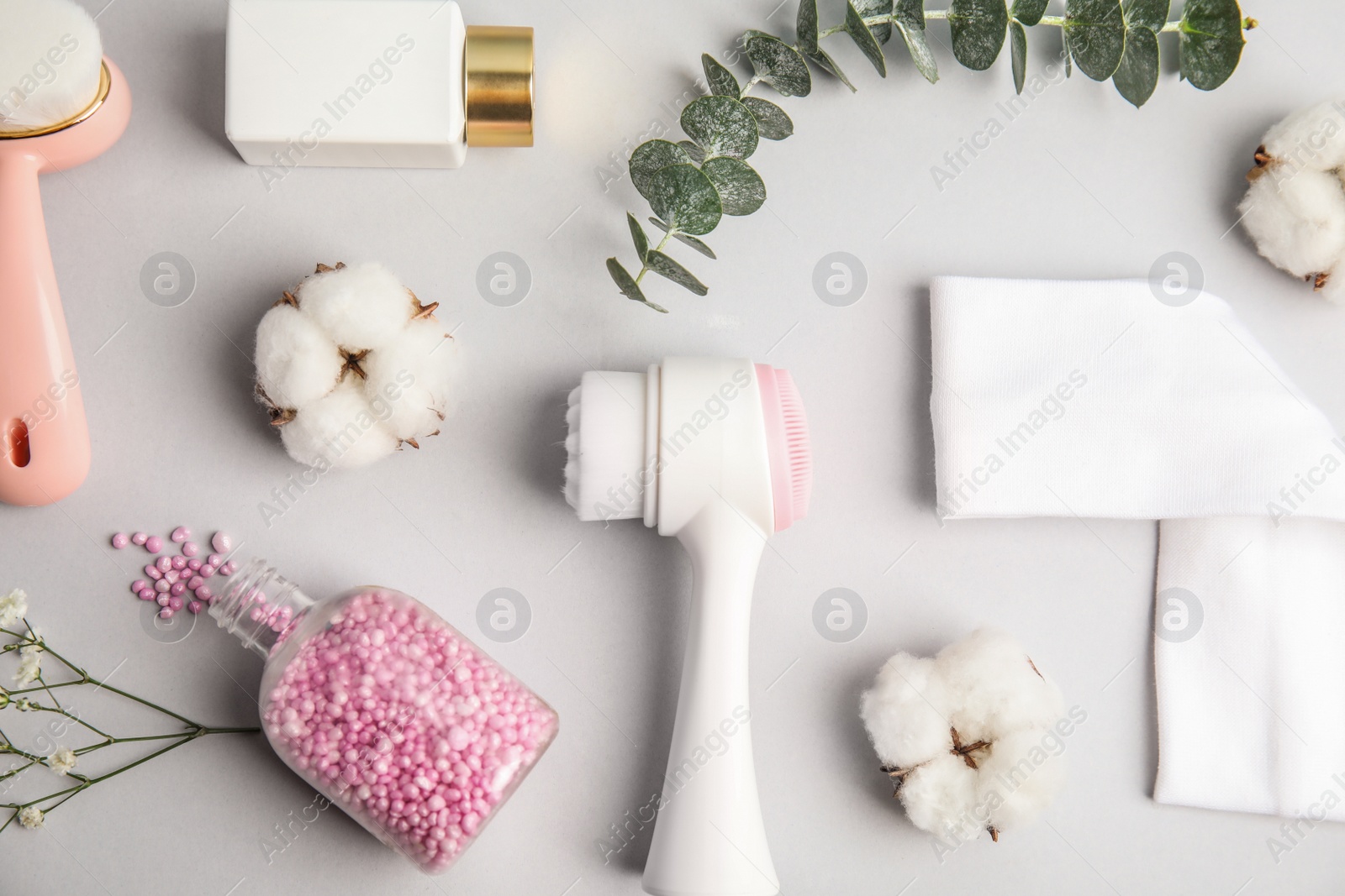 Photo of Flat lay composition with face cleansing brushes on light grey background. Cosmetic accessories