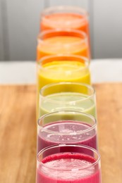 Photo of Many different tasty smoothies on wooden board