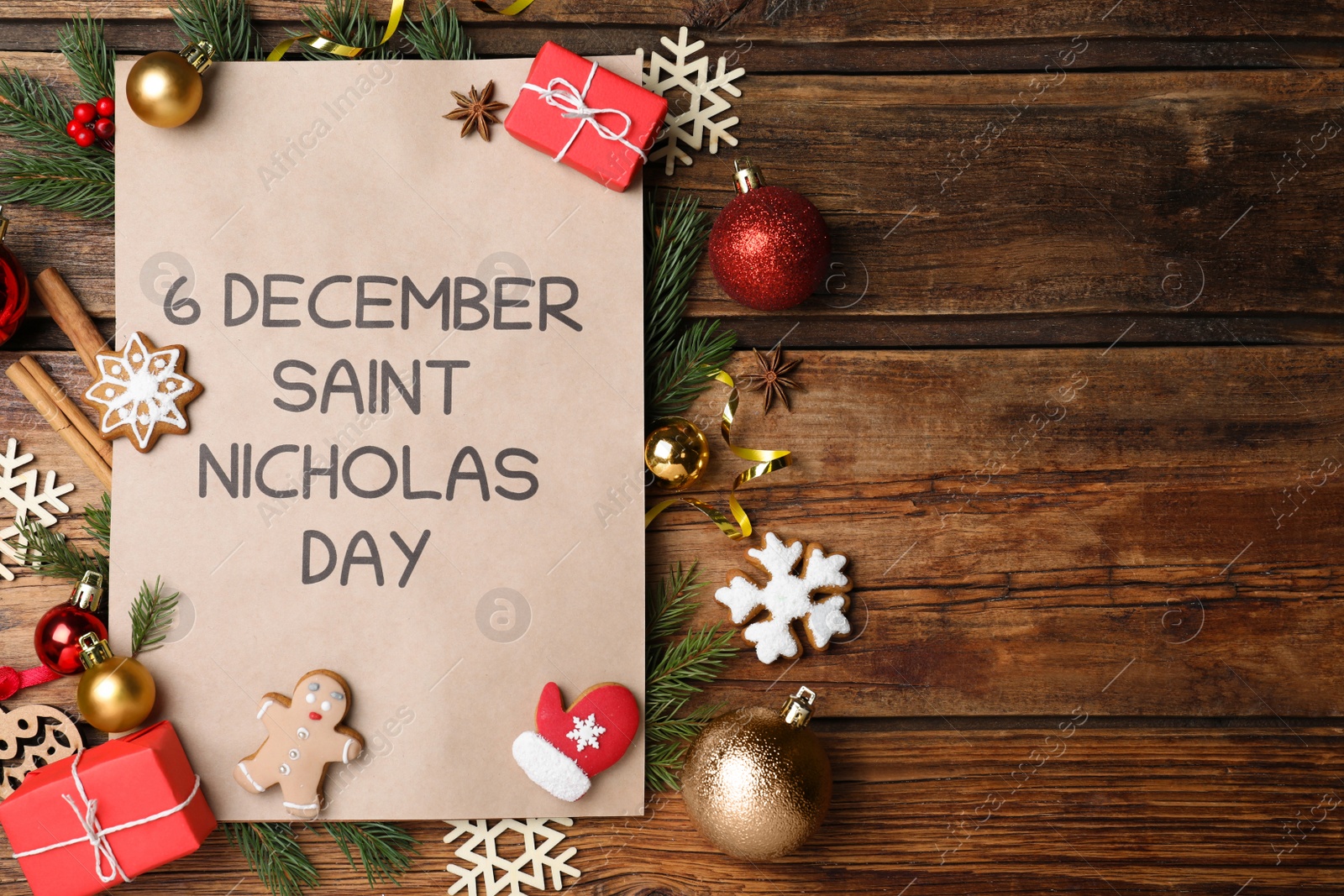 Photo of Sheet of paper with words 6 December Saint Nicholas Day and festive decor on wooden table, flat lay. Space for text