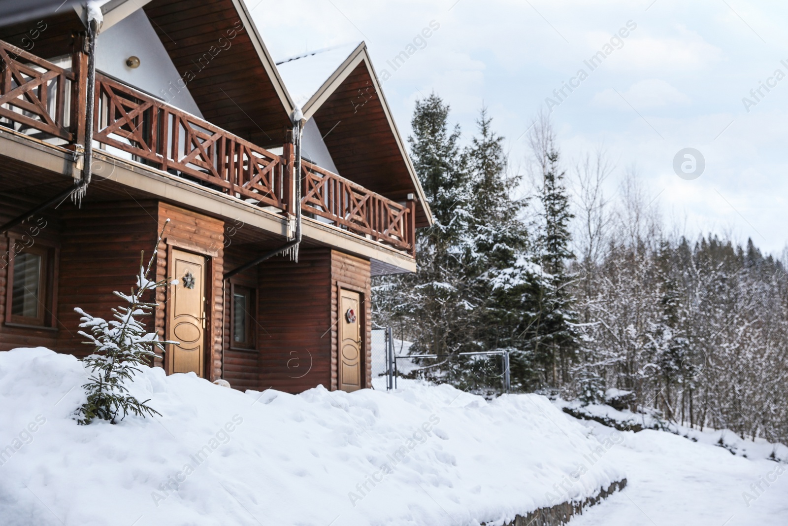 Photo of Modern wooden hotel covered with snow. Winter vacation