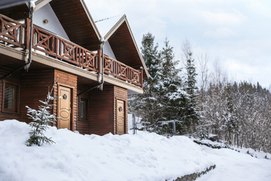 Photo of Modern wooden hotel covered with snow. Winter vacation