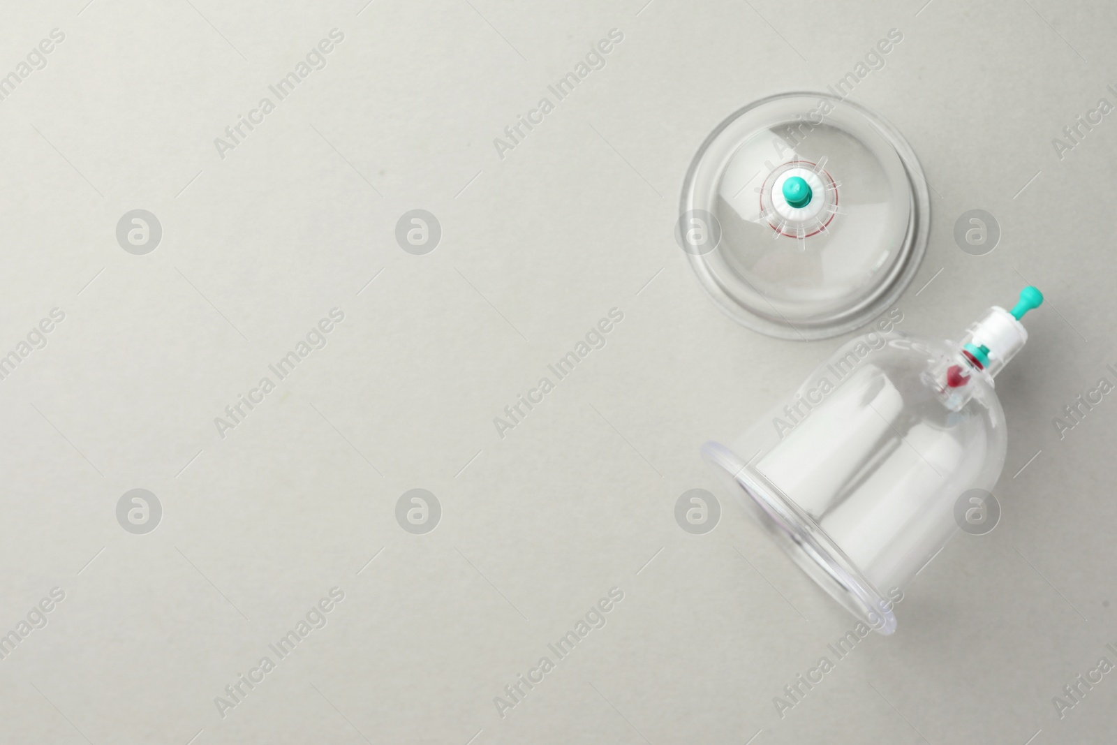 Photo of Plastic cups on light grey background, flat lay with space for text. Cupping therapy