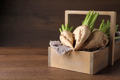 Photo of Basket with fresh sugar beets on wooden table. Space for text