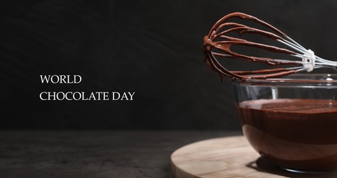 Image of World Chocolate Day. Bowl and whisk with yummy chocolate cream on black table, closeup. Banner design
