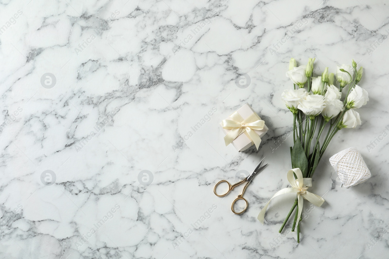 Photo of Flat lay composition with scissors and flowers on white marble background, space for text