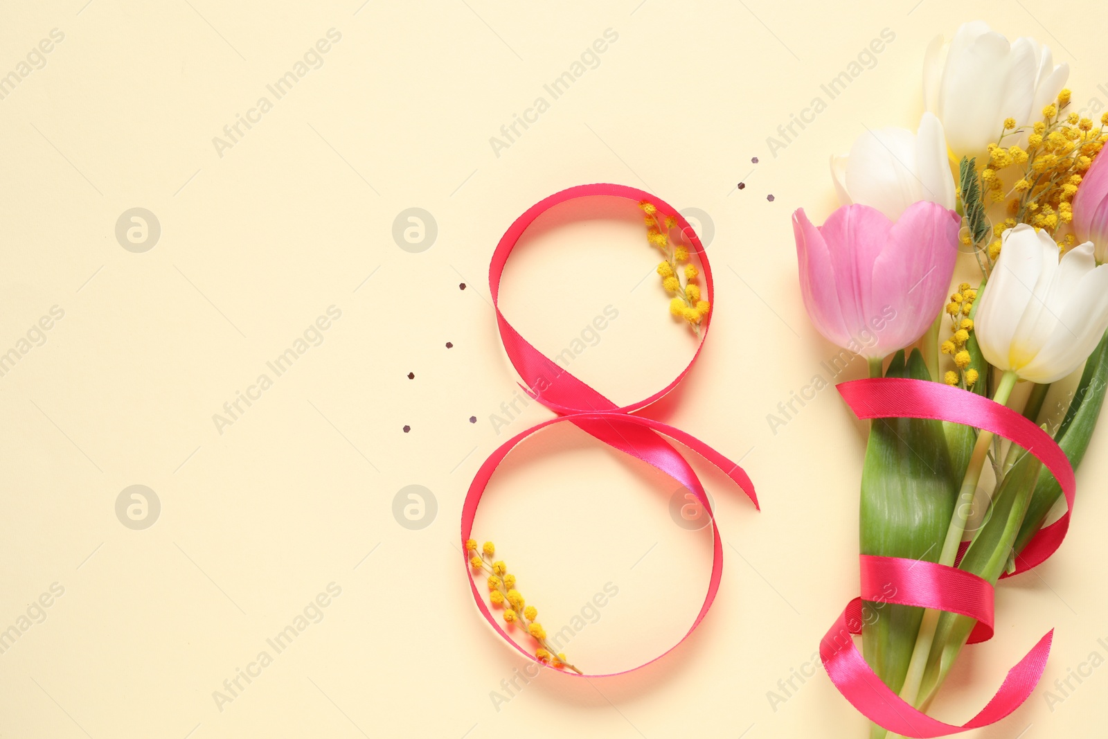 Photo of 8th of March greeting card design with red ribbon, beautiful flowers and space for text on beige background, flat lay. International Women's day