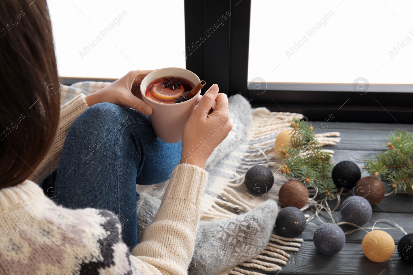 Photo of Woman relaxing with hot winter drink near window. Cozy season