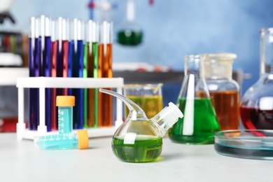 Photo of Different glassware with samples on table in chemistry laboratory