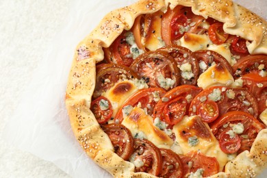 Photo of Tasty galette with tomato and cheese (Caprese galette) on light textured table, top view