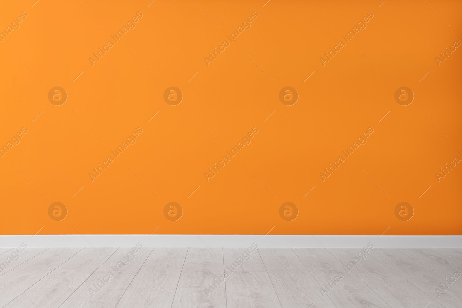 Photo of Empty room with orange wall and wooden floor