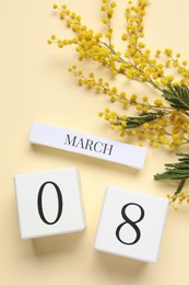 Photo of International Women's day - 8th of March. Wooden block calendar and beautiful flowers on beige background, flat lay