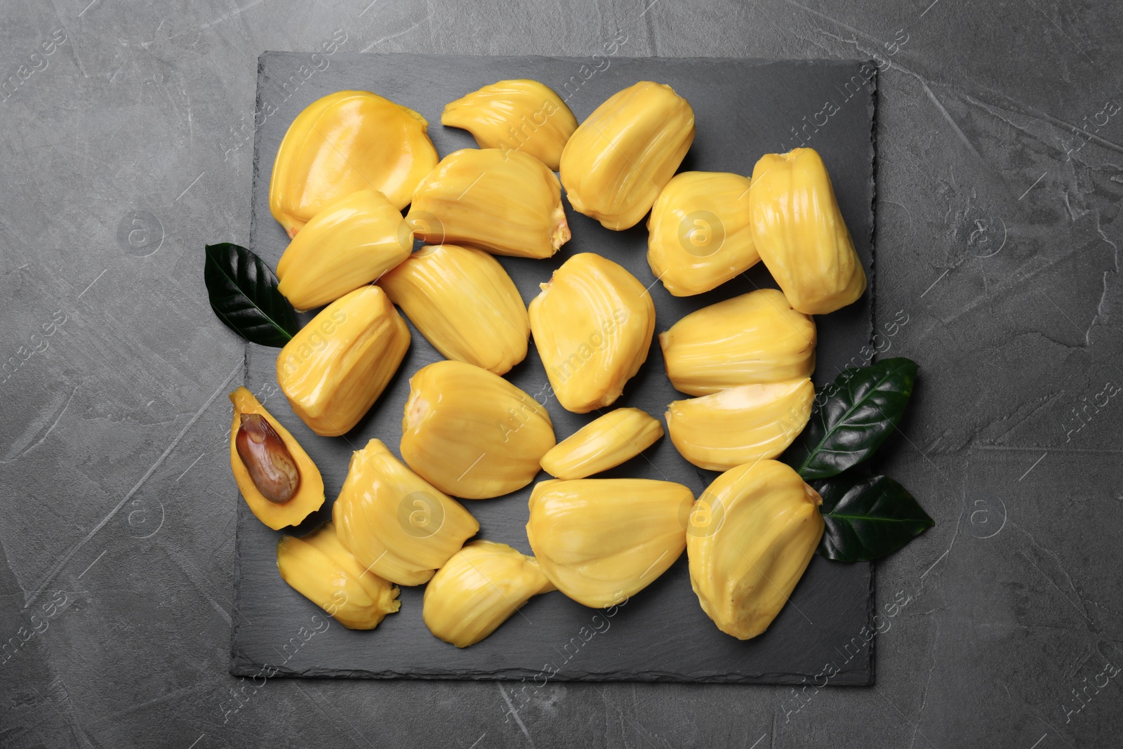 Photo of Delicious exotic jackfruit bulbs on grey table, top view