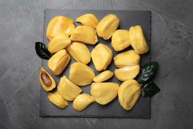 Photo of Delicious exotic jackfruit bulbs on grey table, top view