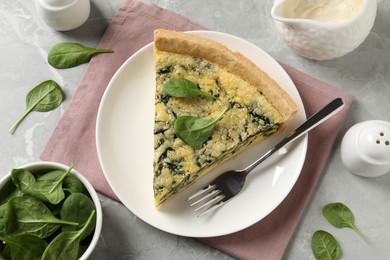 Photo of Piece of delicious spinach pie served on light marble table, flat lay