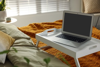 White tray with modern laptop on bed indoors, space for text