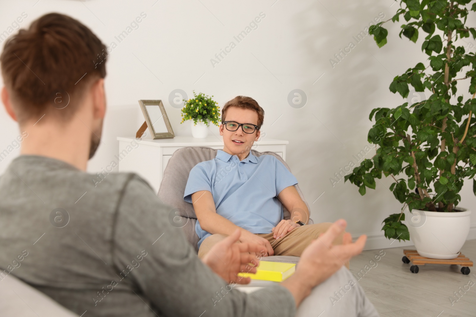 Photo of Father talking with his teenager son at home