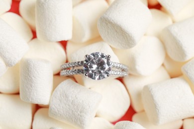 Photo of Luxury jewelry. Stylish presentation of elegant ring on marshmallows, top view