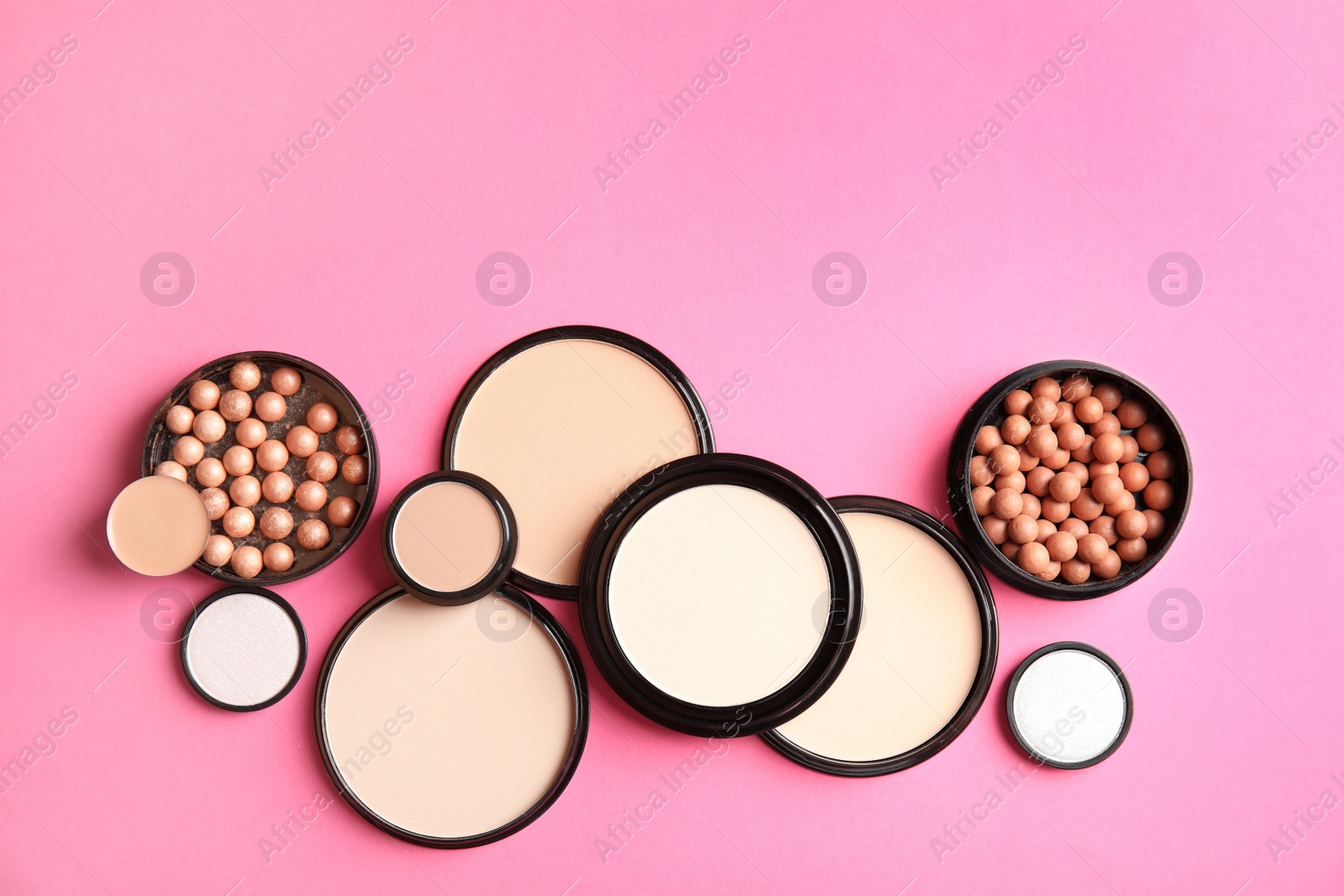 Photo of Flat lay composition with various makeup face powders on color background. Space for text